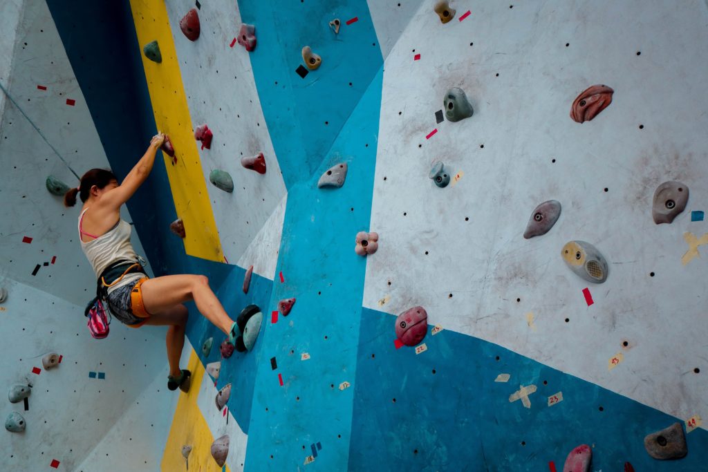 A woman climbing an blue wall